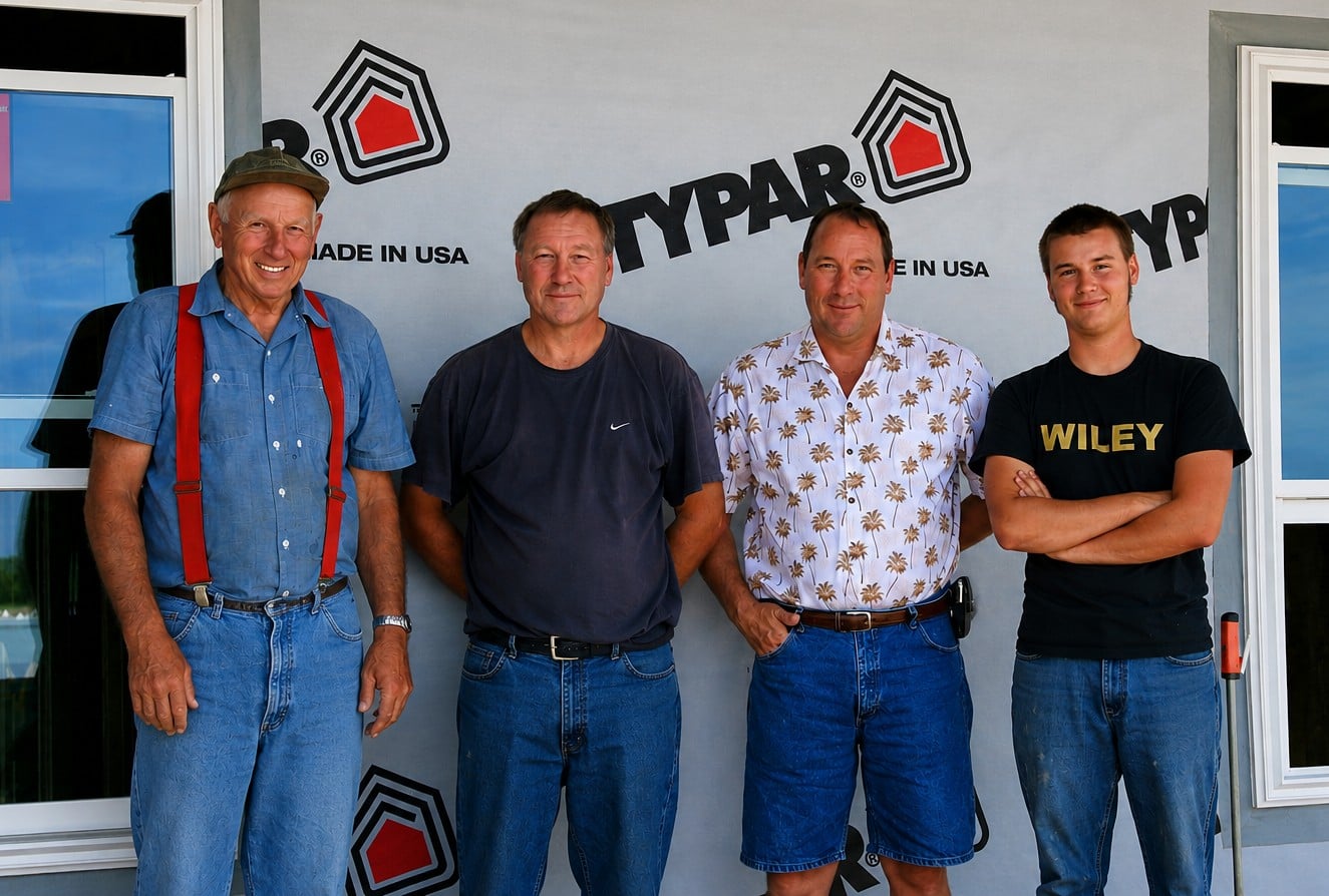 Three generations of the Feikes family standing together at a home construction site
