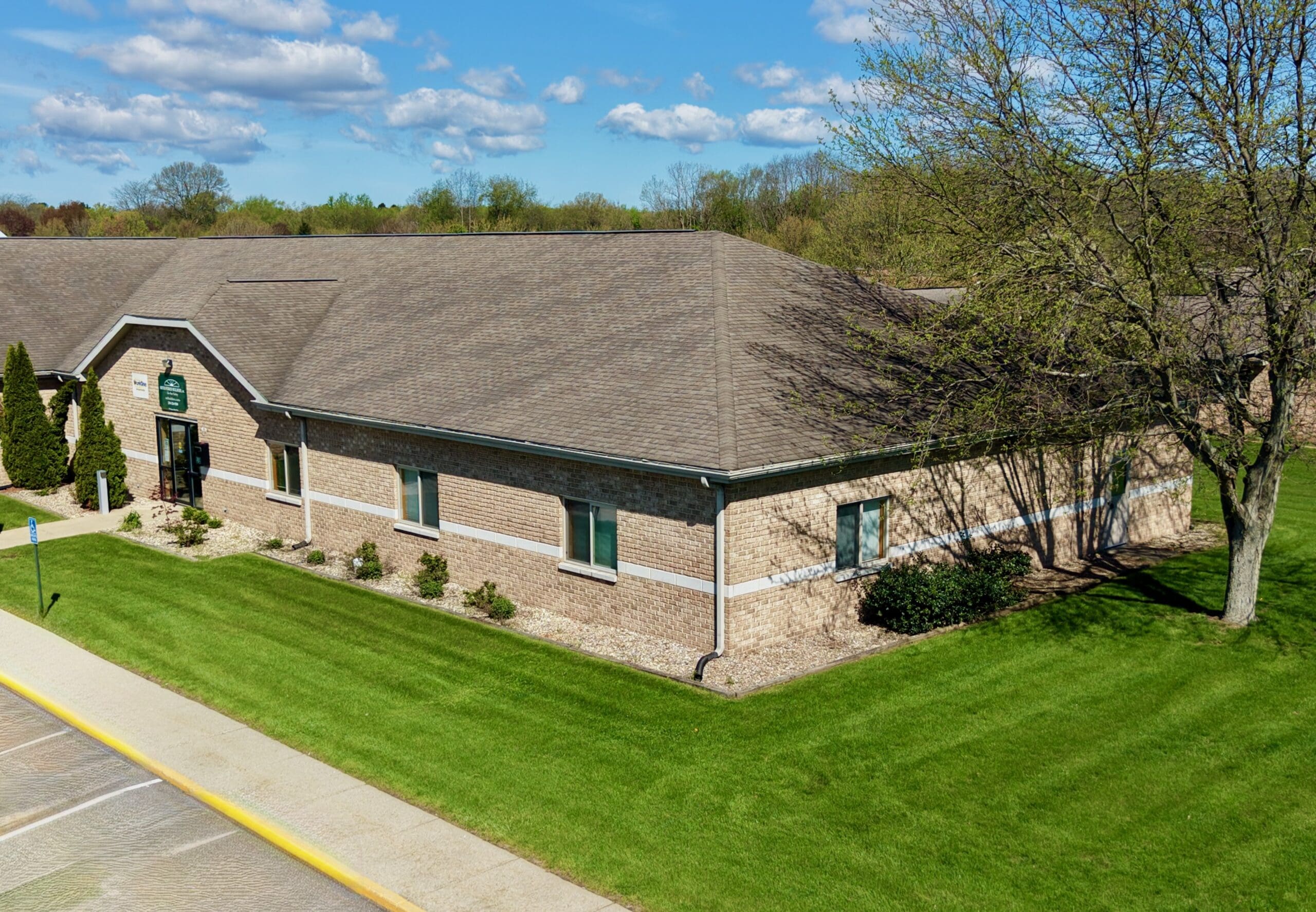 Brick and stone office building with a landscaped lawn at Sagamore Business Center in La Porte, Indiana