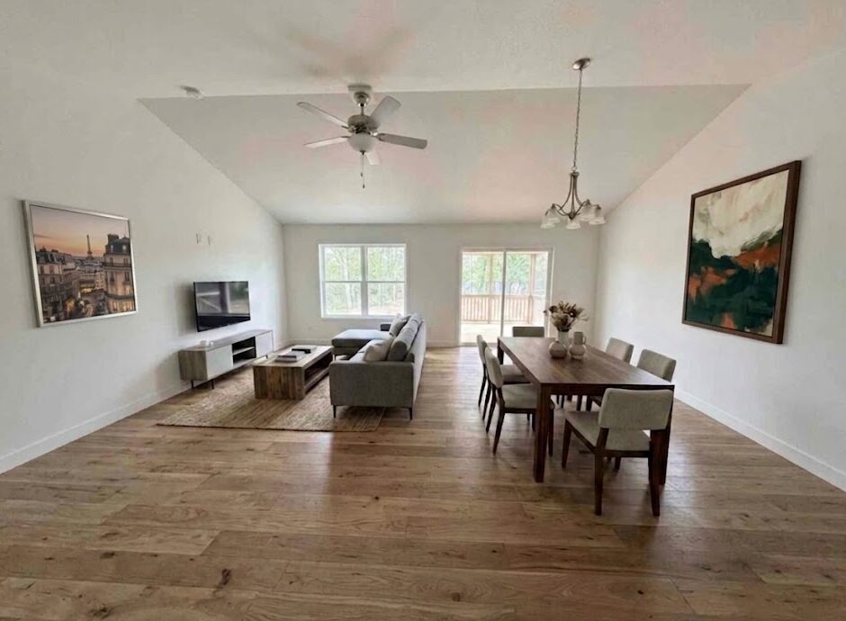 Open living and dining space with vaulted ceiling and wood floors at 74 Prince William Court in Whispering Meadows
