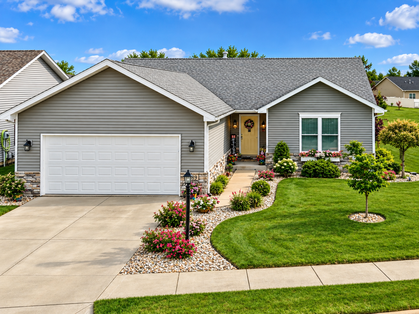 Dans Den model home with gray siding and landscaped front yard in Whispering Meadows, La Porte